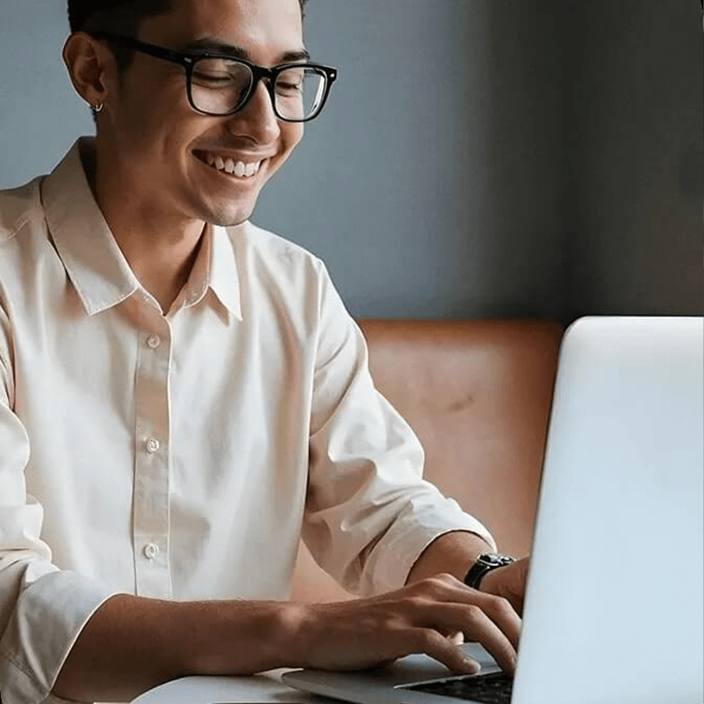 A man smiling while using laptop